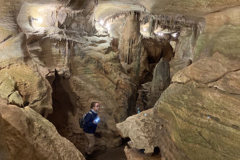 a man standing in front of a large rock