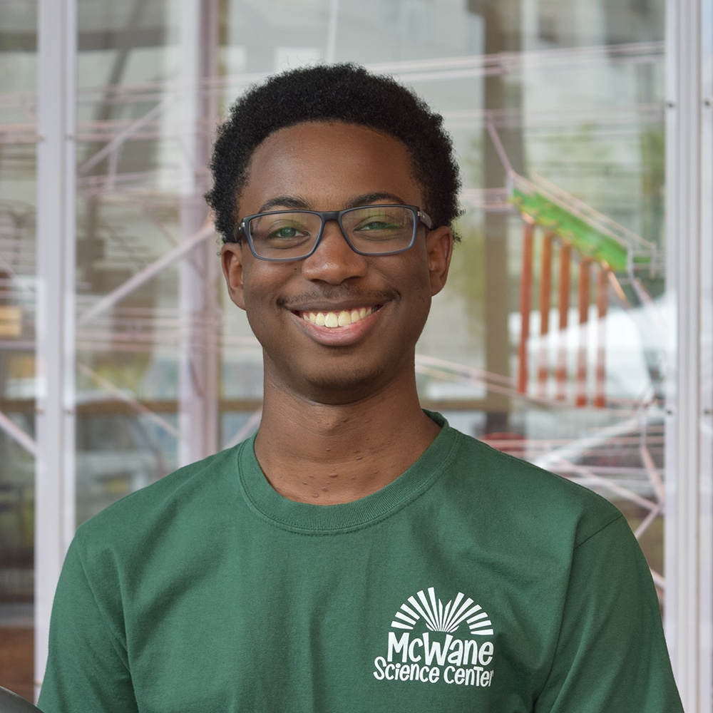 a man wearing glasses and smiling at the camera